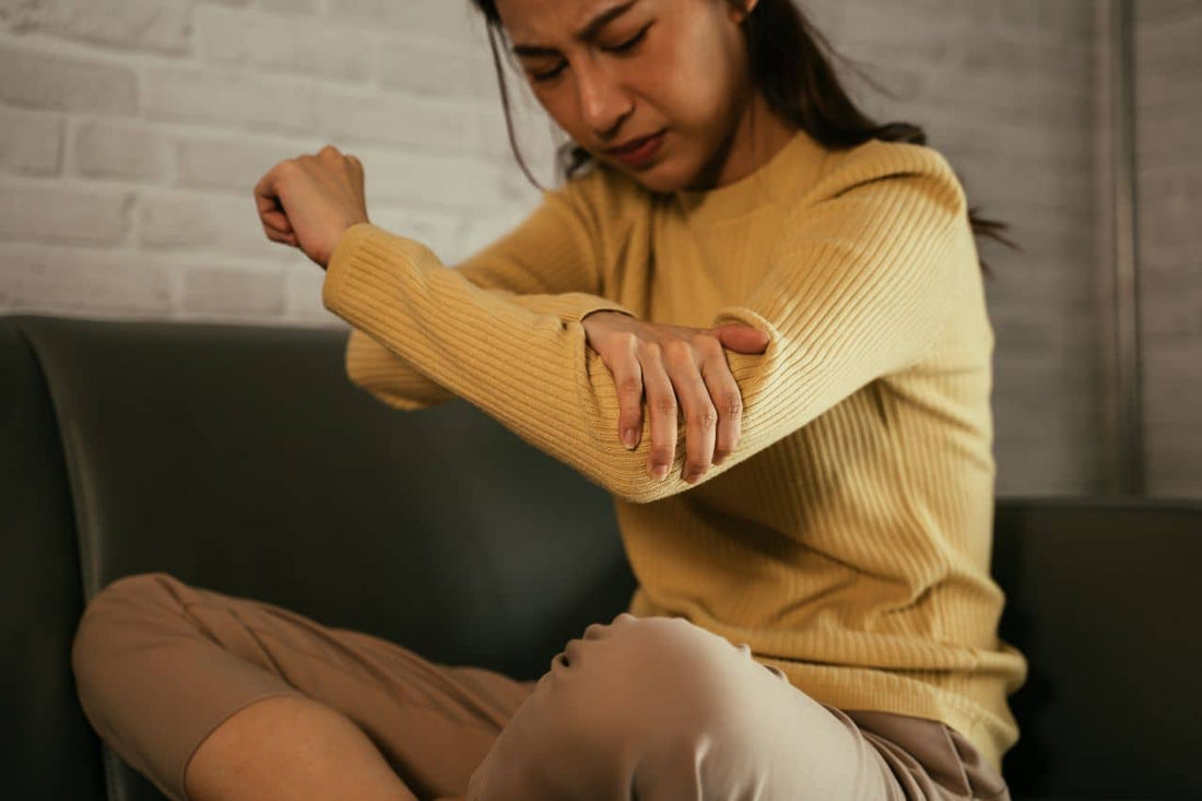 Young female holding her elbow